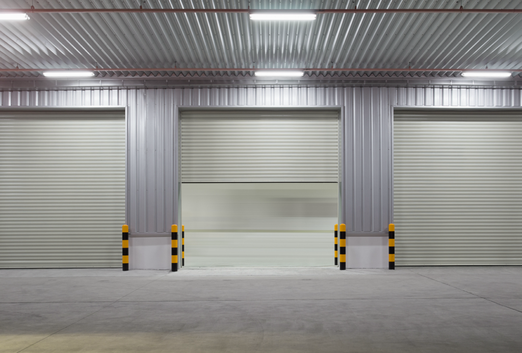 Interior view of three garage doors illuminated by overhead lights. Interior view of three garage doors illuminated by overhead lights.